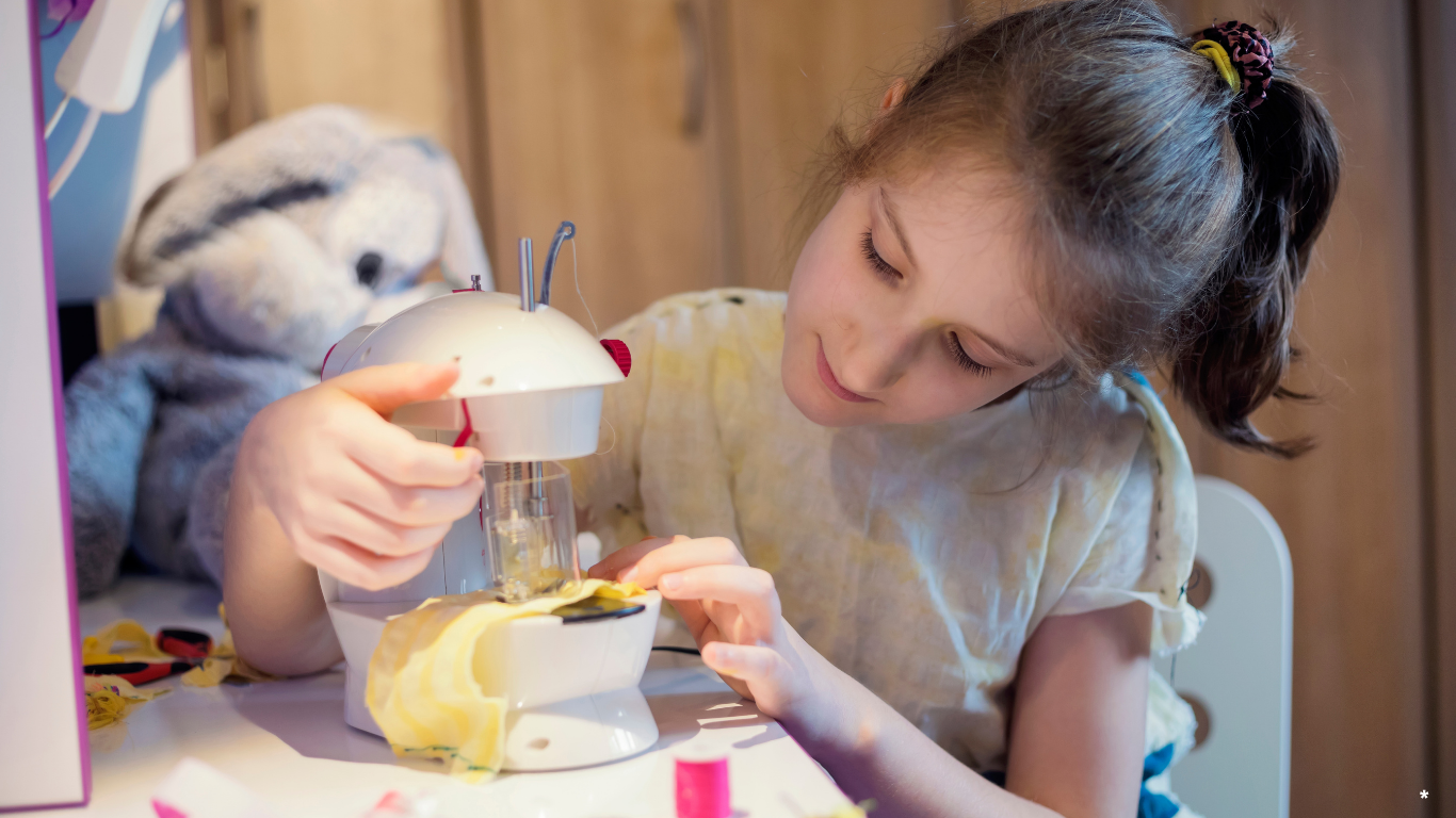 Young girl playing with a toy kitchen set at a table.